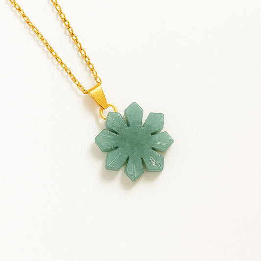 Jade Sun-shaped pendant on a gold chain against a white background